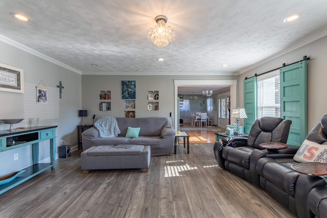 living room featuring a chandelier, a barn door, and hardwood / wood-style floors