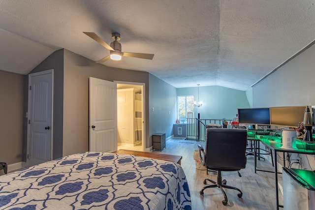 bedroom with a textured ceiling, lofted ceiling, light wood-type flooring, and ceiling fan with notable chandelier