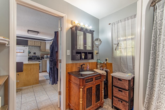 bathroom with vanity, decorative backsplash, and tile patterned flooring