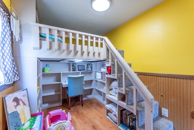 bedroom featuring wooden walls and hardwood / wood-style floors