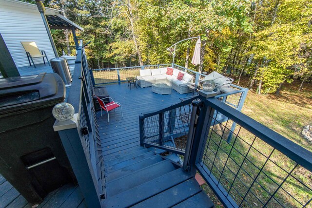 wooden terrace featuring an outdoor living space and a grill