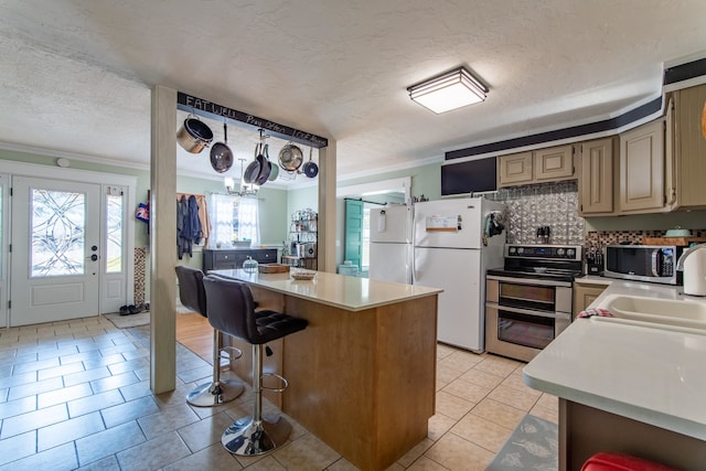 kitchen with tasteful backsplash, a kitchen bar, ornamental molding, sink, and stainless steel appliances