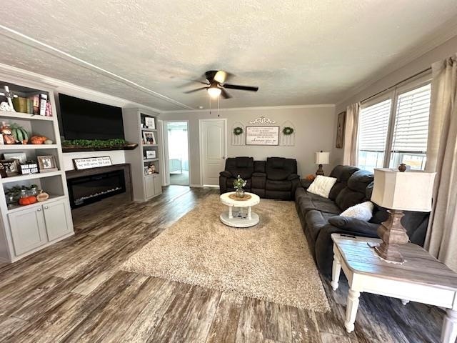 living room with a textured ceiling, ceiling fan, plenty of natural light, and dark hardwood / wood-style flooring