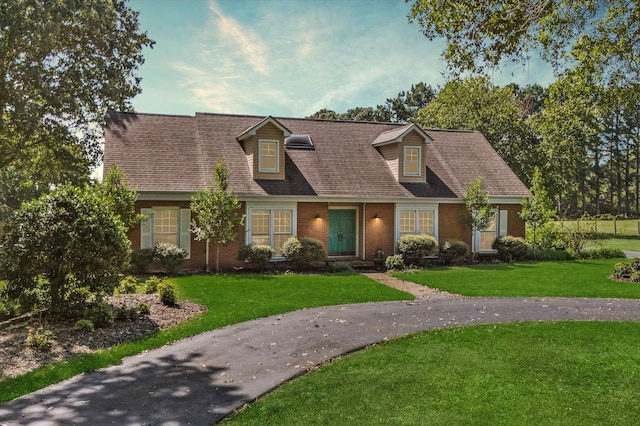 cape cod-style house with a front yard