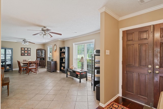 foyer with light tile patterned floors, ornamental molding, a textured ceiling, and ceiling fan