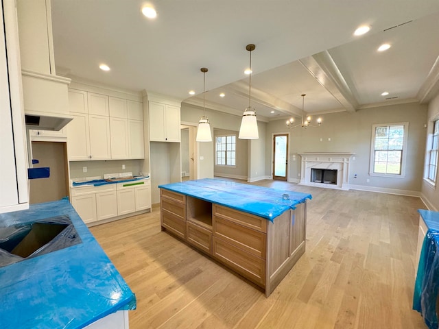 kitchen featuring white cabinets, light stone counters, and a large island