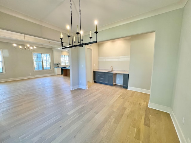 unfurnished dining area featuring sink, light hardwood / wood-style floors, and a notable chandelier