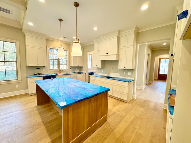 kitchen with a kitchen island, a healthy amount of sunlight, and light hardwood / wood-style floors