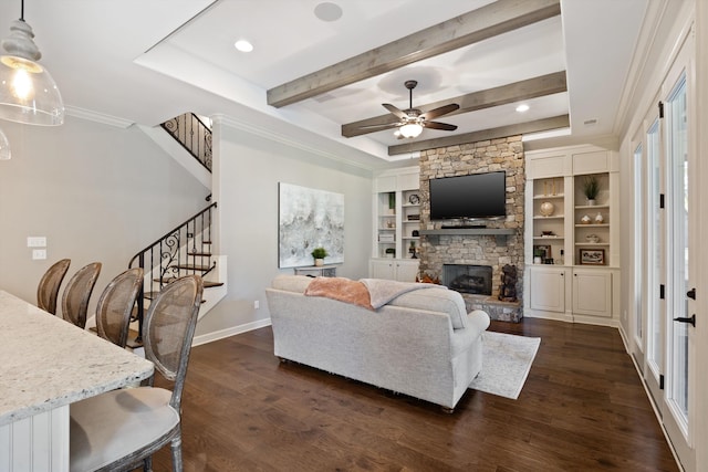 living room with a stone fireplace, ornamental molding, ceiling fan, and dark hardwood / wood-style flooring