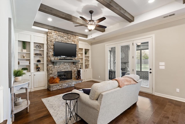 living room with beam ceiling, ceiling fan, ornamental molding, dark hardwood / wood-style floors, and a fireplace