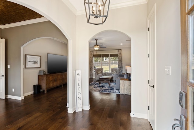 foyer entrance featuring crown molding, dark wood-type flooring, and ceiling fan with notable chandelier