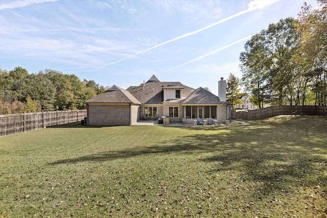 back of house featuring a patio area and a lawn