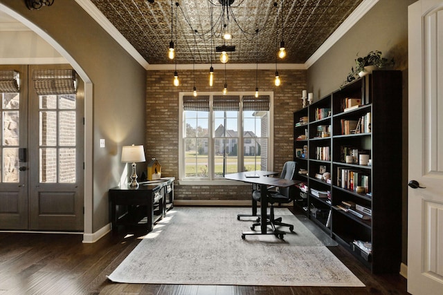 office with french doors, crown molding, brick wall, a chandelier, and dark hardwood / wood-style floors