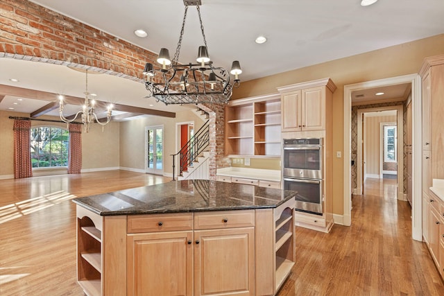 kitchen featuring light hardwood / wood-style flooring, a healthy amount of sunlight, a center island, and hanging light fixtures