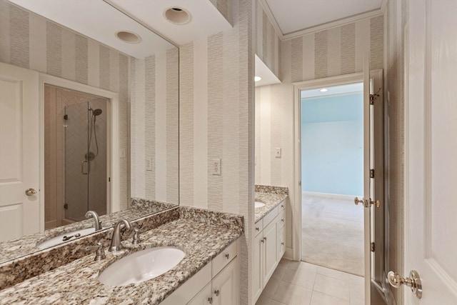 bathroom with walk in shower, vanity, and tile patterned flooring