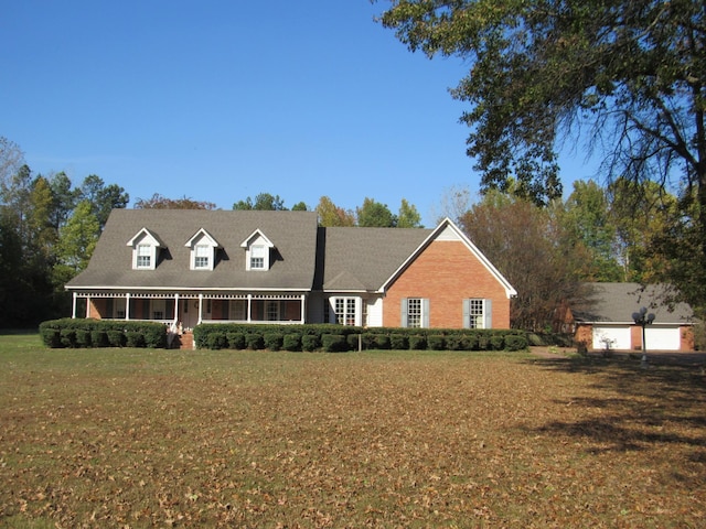 cape cod-style house featuring a front yard