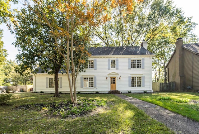 colonial-style house featuring a front lawn