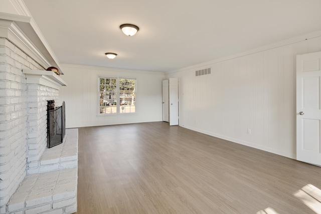 unfurnished living room with crown molding, a fireplace, and wood-type flooring