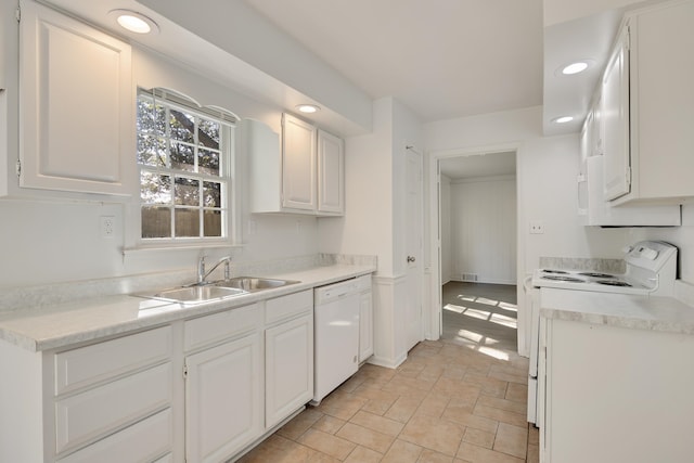 kitchen featuring sink, white cabinets, and white appliances