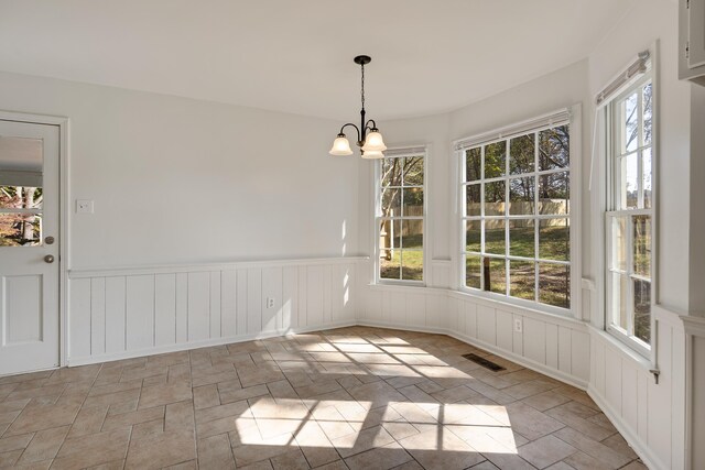 unfurnished dining area featuring an inviting chandelier