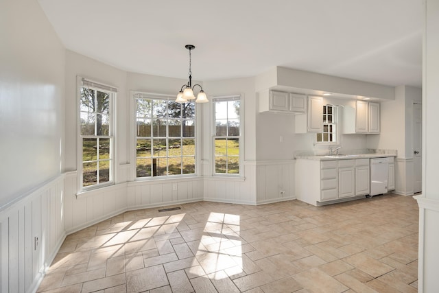 unfurnished dining area with an inviting chandelier, plenty of natural light, and sink