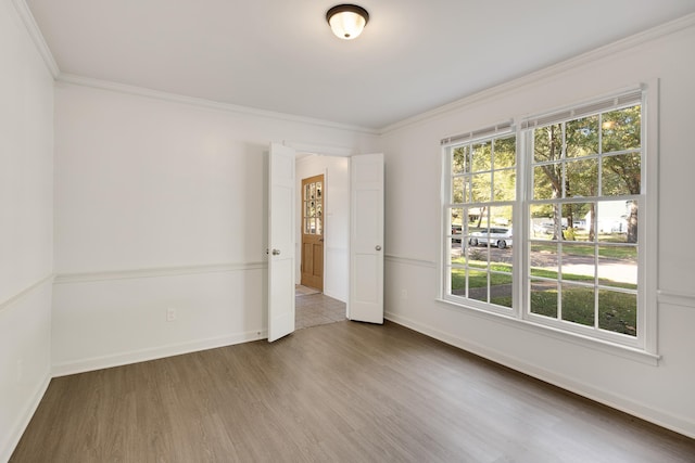 spare room with hardwood / wood-style flooring and crown molding