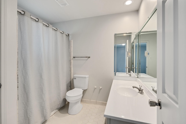 bathroom with tile patterned flooring, vanity, and toilet