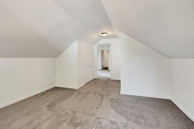 bonus room with light carpet and lofted ceiling