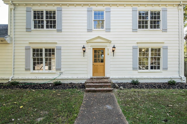 colonial inspired home with a front lawn