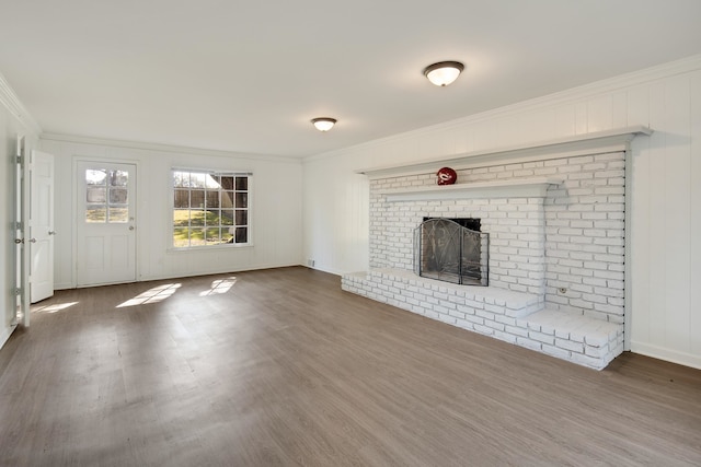 unfurnished living room with ornamental molding, dark wood-type flooring, and a brick fireplace