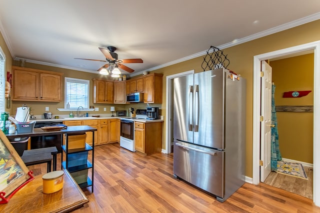 kitchen with appliances with stainless steel finishes, light hardwood / wood-style flooring, ceiling fan, and crown molding