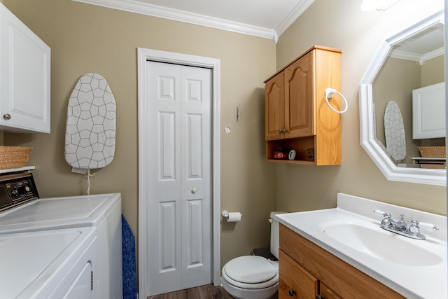 bathroom featuring hardwood / wood-style floors, toilet, vanity, ornamental molding, and washer and clothes dryer