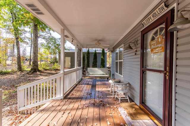 wooden deck featuring covered porch and ceiling fan