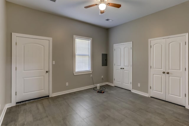 foyer entrance with a ceiling fan, baseboards, visible vents, and dark wood-type flooring