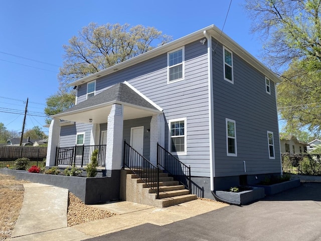 view of front of house featuring fence and covered porch