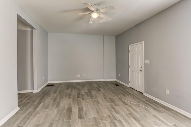 unfurnished room featuring light wood-type flooring, a ceiling fan, and baseboards