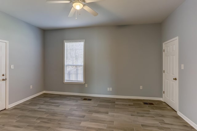 spare room with ceiling fan, wood finished floors, and visible vents