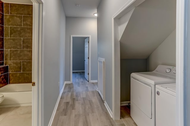 laundry room with separate washer and dryer, laundry area, baseboards, and light wood-type flooring