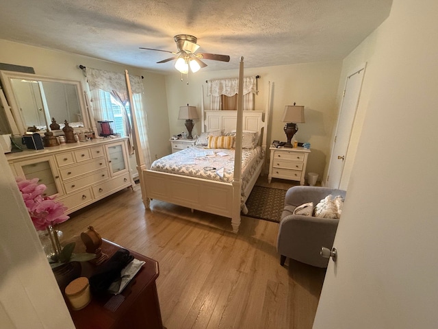 bedroom with a textured ceiling, light wood-type flooring, and ceiling fan