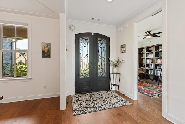 entryway with hardwood / wood-style floors, french doors, crown molding, and ceiling fan