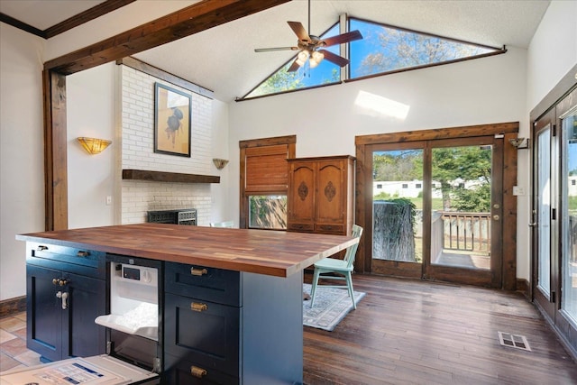 kitchen with crown molding, dark hardwood / wood-style flooring, ceiling fan, wooden counters, and blue cabinetry