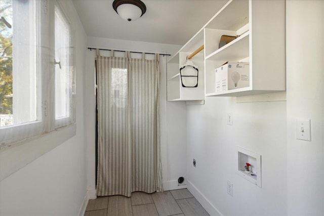 laundry area with hookup for an electric dryer, hookup for a washing machine, and hardwood / wood-style flooring