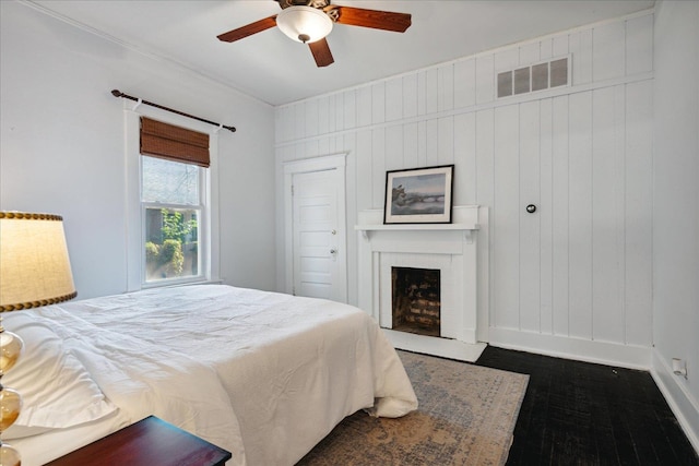 bedroom featuring a closet, ceiling fan, and wood walls