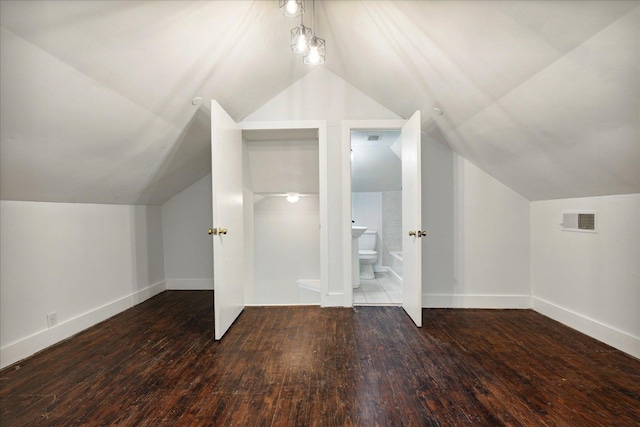 additional living space featuring dark hardwood / wood-style floors and vaulted ceiling