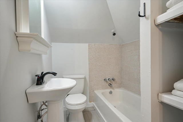 bathroom with toilet, lofted ceiling, and tile patterned flooring