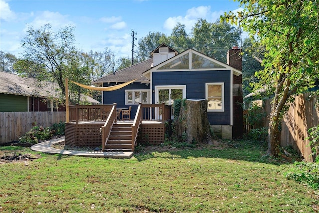 rear view of house with a deck and a yard