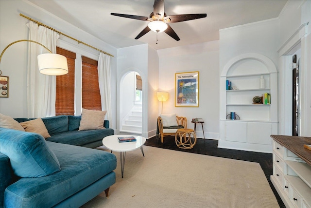 living room with ceiling fan, built in features, and dark hardwood / wood-style floors