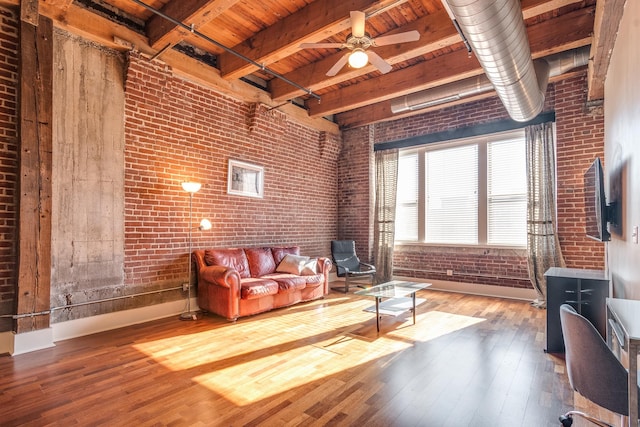 living room with wood ceiling, beam ceiling, ceiling fan, hardwood / wood-style flooring, and brick wall