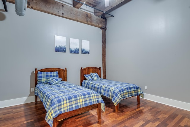 bedroom featuring beamed ceiling and dark hardwood / wood-style flooring