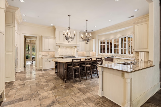 kitchen with kitchen peninsula, decorative backsplash, a kitchen breakfast bar, light stone countertops, and pendant lighting